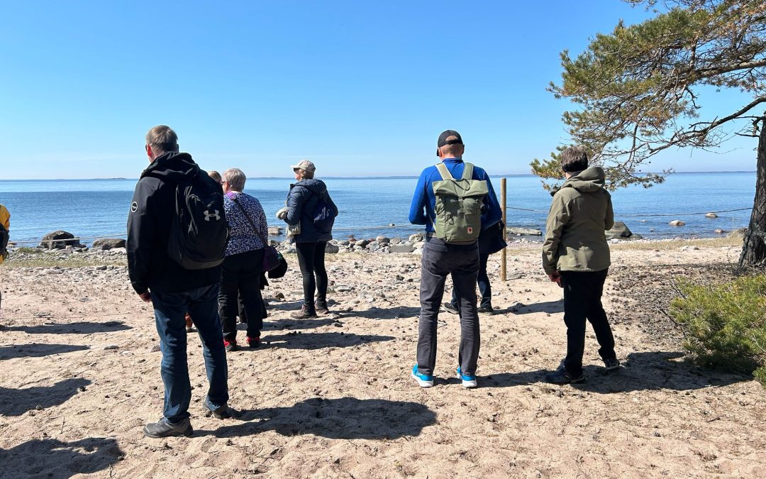 Ihmisiä hiekkarannalla saaristossa.